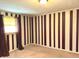 A bedroom is painted with stripes of tan and brown, and a window lets in light at 243 E Benton St, Alexandria, IN 46001