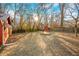 Large backyard with sparse grass features a shed and a fire pit under the trees at 251 E South St, Franklin, IN 46131