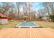 Picturesque backyard showcasing a wooden deck, covered pool, gazebo, fire pit, mature trees, and vibrant landscaping, perfect for relaxation at 251 E South St, Franklin, IN 46131