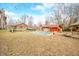 Spacious backyard showcasing a covered pool, brick buildings, wooden deck, serene landscaping, and mature trees, perfect for recreation at 251 E South St, Franklin, IN 46131