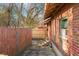 The backyard features an exterior brick wall with string lights and a wooden fence for privacy at 251 E South St, Franklin, IN 46131