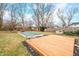 Spacious backyard featuring a wooden deck, covered pool, mature trees, inviting gazebo, and well-maintained lawn, perfect for recreation at 251 E South St, Franklin, IN 46131