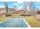 Expansive backyard view featuring a covered pool, brick house, wooden deck, lush lawn, and serene landscaping perfect for outdoor living at 251 E South St, Franklin, IN 46131