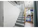 Basement staircase featuring painted concrete walls and stairs, contrasted by visible utilities and storage, and a glimpse of natural light at 251 E South St, Franklin, IN 46131