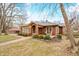 Classic brick home with a red front door, front porch and mature trees providing shade at 251 E South St, Franklin, IN 46131