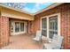 Relaxing front porch with tiled flooring, brick facade, and seating, perfect for enjoying the outdoors at 251 E South St, Franklin, IN 46131