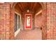 Inviting front porch with brick archway, tiled flooring and a bright red front door at 251 E South St, Franklin, IN 46131