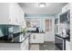 Well-lit kitchen with stainless steel appliances, white cabinets, and unique tile flooring at 251 E South St, Franklin, IN 46131