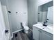 Modern bathroom with white vanity, black fixtures, and wood-look vinyl flooring at 310 N Monroe St, Muncie, IN 47305