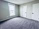 This bedroom has neutral paint, carpet, one window, and two doors at 310 N Monroe St, Muncie, IN 47305