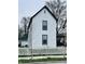 Exterior view of a two-story home with white siding and black trim, enhanced by a white picket fence at 310 N Monroe St, Muncie, IN 47305