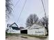 View of the house and garage featuring white siding and a connecting carport at 310 N Monroe St, Muncie, IN 47305