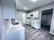 Open kitchen featuring a stainless steel sink, white cabinets, and plank flooring at 310 N Monroe St, Muncie, IN 47305