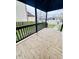 Inviting porch with a wooden deck and black railing, creating an appealing outdoor space at 310 N Monroe St, Muncie, IN 47305