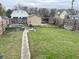 Spacious backyard with a shed, overgrown greenery, and a concrete walkway at 330 N Beville Ave, Indianapolis, IN 46201