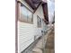 Home's side exterior with white siding, brown trim, and a chain-link gate at 330 N Beville Ave, Indianapolis, IN 46201