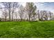 Expansive backyard with lush green grass, mature trees, and a charming storage shed at 3393 Paisley Pointe, Whitestown, IN 46075