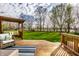 Inviting wooden deck with comfortable seating and a pergola, overlooking a large yard at 3393 Paisley Pointe, Whitestown, IN 46075