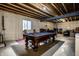 Spacious basement area with a pool table and exposed ceiling, offering potential for entertainment and recreation at 3393 Paisley Pointe, Whitestown, IN 46075