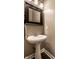 Elegant pedestal sink bathroom with dark framed mirror and neutral wall color at 3393 Paisley Pointe, Whitestown, IN 46075