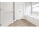 Bright bathroom featuring a tub, window and white doors, showcasing a clean and modern design at 3393 Paisley Pointe, Whitestown, IN 46075
