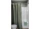 Bathroom area showcasing the commode and shower stall with a patterned green shower curtain at 3393 Paisley Pointe, Whitestown, IN 46075
