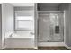 Bright bathroom featuring a separate tub and glass enclosed shower, showcasing a clean and modern design at 3393 Paisley Pointe, Whitestown, IN 46075