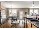 Kitchen with stainless sink, wood cabinets, and view of dining area with backyard access and natural light at 3393 Paisley Pointe, Whitestown, IN 46075