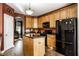 Spacious kitchen with wood cabinets, black appliances, a functional island, and modern overhead lighting at 3393 Paisley Pointe, Whitestown, IN 46075