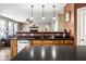 Open kitchen with black countertops, wooden cabinets, and stainless steel dishwasher overlooking the living room at 3393 Paisley Pointe, Whitestown, IN 46075