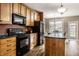 Stylish kitchen featuring modern appliances, wood cabinetry, and an island with a black countertop at 3393 Paisley Pointe, Whitestown, IN 46075