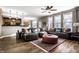 Spacious living room features a comfortable leather sectional, hardwood floors, and plenty of natural light at 3393 Paisley Pointe, Whitestown, IN 46075