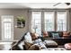 Inviting living room featuring a sectional sofa, large windows, and modern decor at 3393 Paisley Pointe, Whitestown, IN 46075