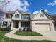 Charming two-story brick home featuring a two-car garage, green shutters, and landscaped front yard at 3607 Mossy Rock Dr, Zionsville, IN 46077