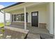 A close-up view of the front porch with a black front door and brick accents at 4057 Knollwood Ave, Franklin, IN 46131