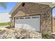 Attached two-car garage featuring a white door, brick accents, and exterior lighting at 4057 Knollwood Ave, Franklin, IN 46131