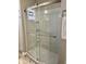 A tiled shower in the bathroom with glass sliding door, with shelves, and a towel rack on the wall at 4205 Rookwood Ave, Indianapolis, IN 46208