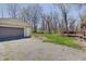 View of the detached garage and back of the house with a patio and a gravel driveway at 4389 S Brooklawn Dr, New Palestine, IN 46163