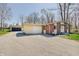 View of the home with brick facade, an attached garage, and gravel driveway at 4389 S Brooklawn Dr, New Palestine, IN 46163