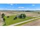 Aerial view displaying a home with an outbuilding on a large, lush lawn bordered by agricultural fields under a blue sky at 4545 W 200 S, Lebanon, IN 46052