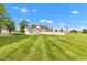 Expansive backyard with lush lawn, mature trees, a fence, and a glimpse of the home at 4545 W 200 S, Lebanon, IN 46052