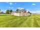 Wide view of the expansive backyard with a wooden fence, lush lawn, and mature trees at 4545 W 200 S, Lebanon, IN 46052