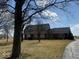 Home exterior partially blocked by trees, displaying its front yard and driveway at 4545 W 200 S, Lebanon, IN 46052