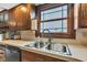 Close up of a kitchen sink with stainless steel fixtures, and wood cabinets at 4545 W 200 S, Lebanon, IN 46052