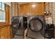 Convenient laundry area with side by side dark grey washing and drying machines, and wood cabinets at 4545 W 200 S, Lebanon, IN 46052