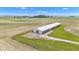 Aerial view featuring a large outbuilding and gravel driveway, situated among open fields under a sunny sky at 4545 W 200 S, Lebanon, IN 46052