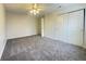 Large bedroom featuring neutral carpet, ceiling fan, and double door closet at 4767 Kelvington Dr, Indianapolis, IN 46254