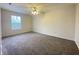 Empty bedroom featuring neutral carpeting, a ceiling fan and natural light from window at 4767 Kelvington Dr, Indianapolis, IN 46254