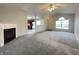 Open-concept living room with fireplace flowing into kitchen with white cabinets at 4767 Kelvington Dr, Indianapolis, IN 46254