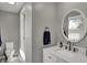 Bathroom featuring a vanity with marble top, white cabinets, a round mirror, and modern fixtures at 5311 Larita Ln, Anderson, IN 46017